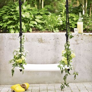 White garden swing with integral planting over garden patio