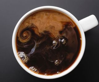 A cup of coffee with milk marbling in it