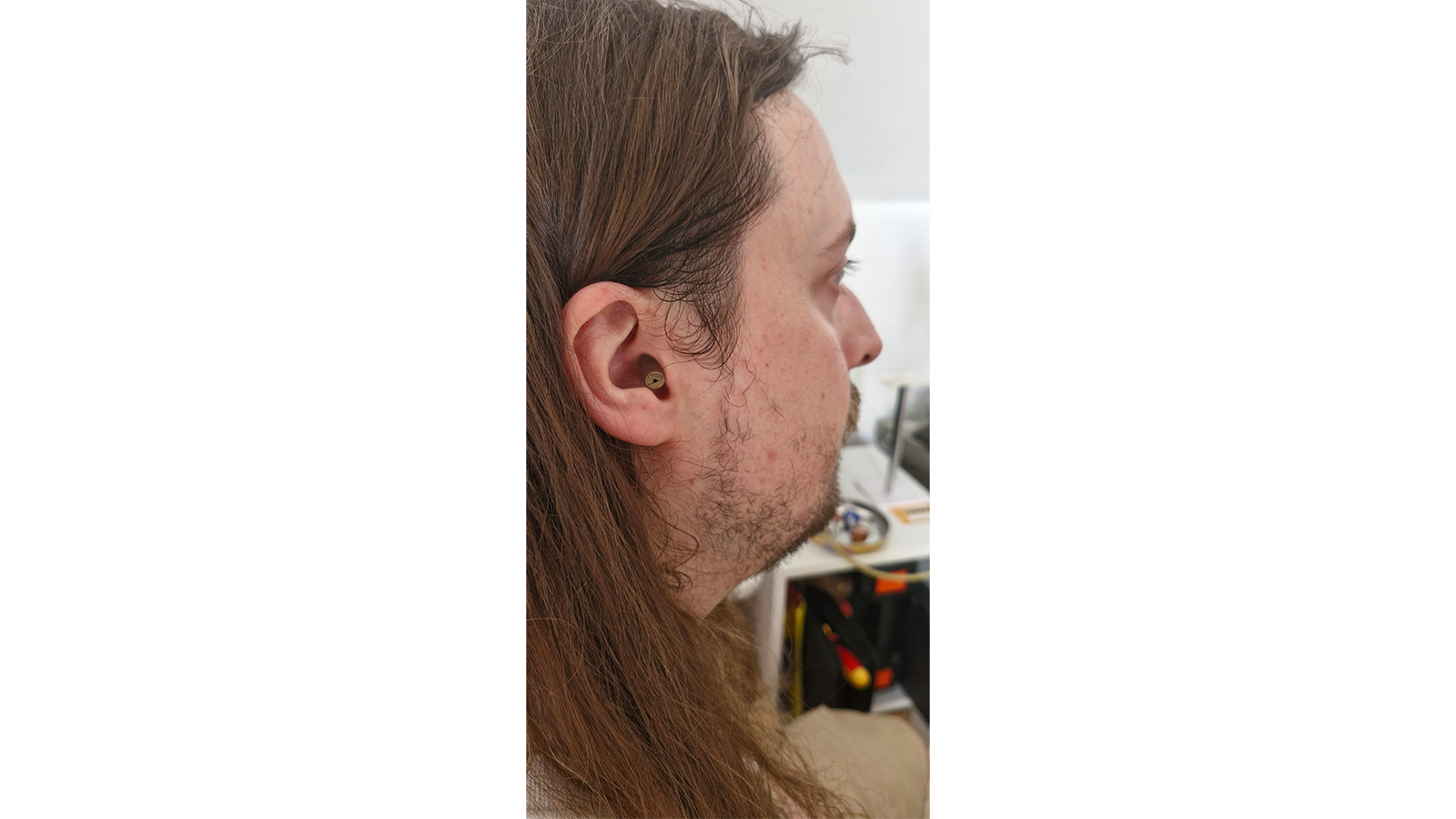 image showing an Alpine MusicSafe earplug in a man's ear
