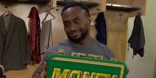 WWE's Big E smiles with the Money In The Bank case in the locker room.