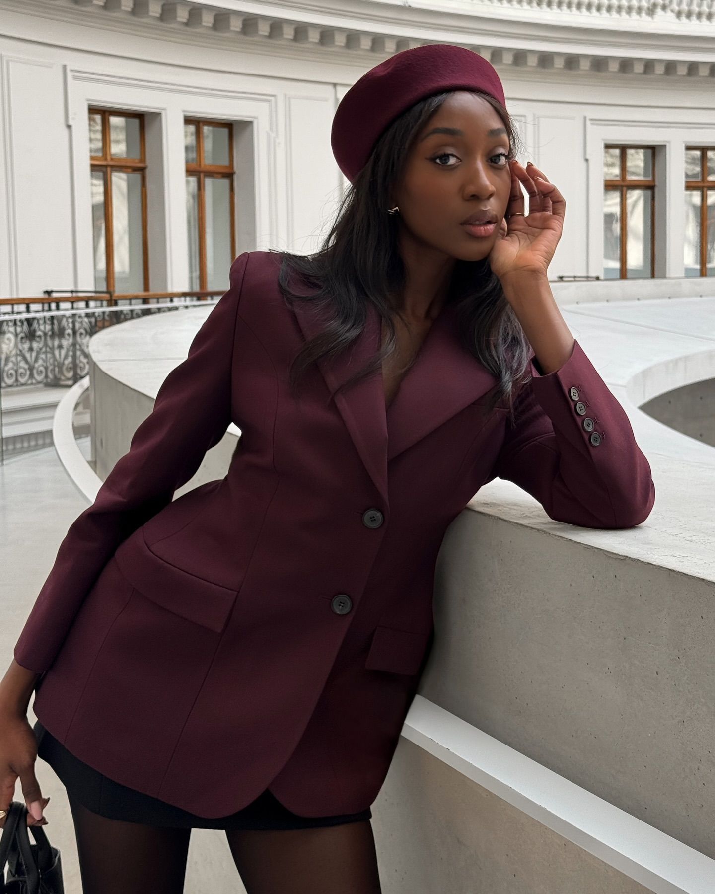 Emmanuelle Koffi in a pillbox hat with straight, shiny hair