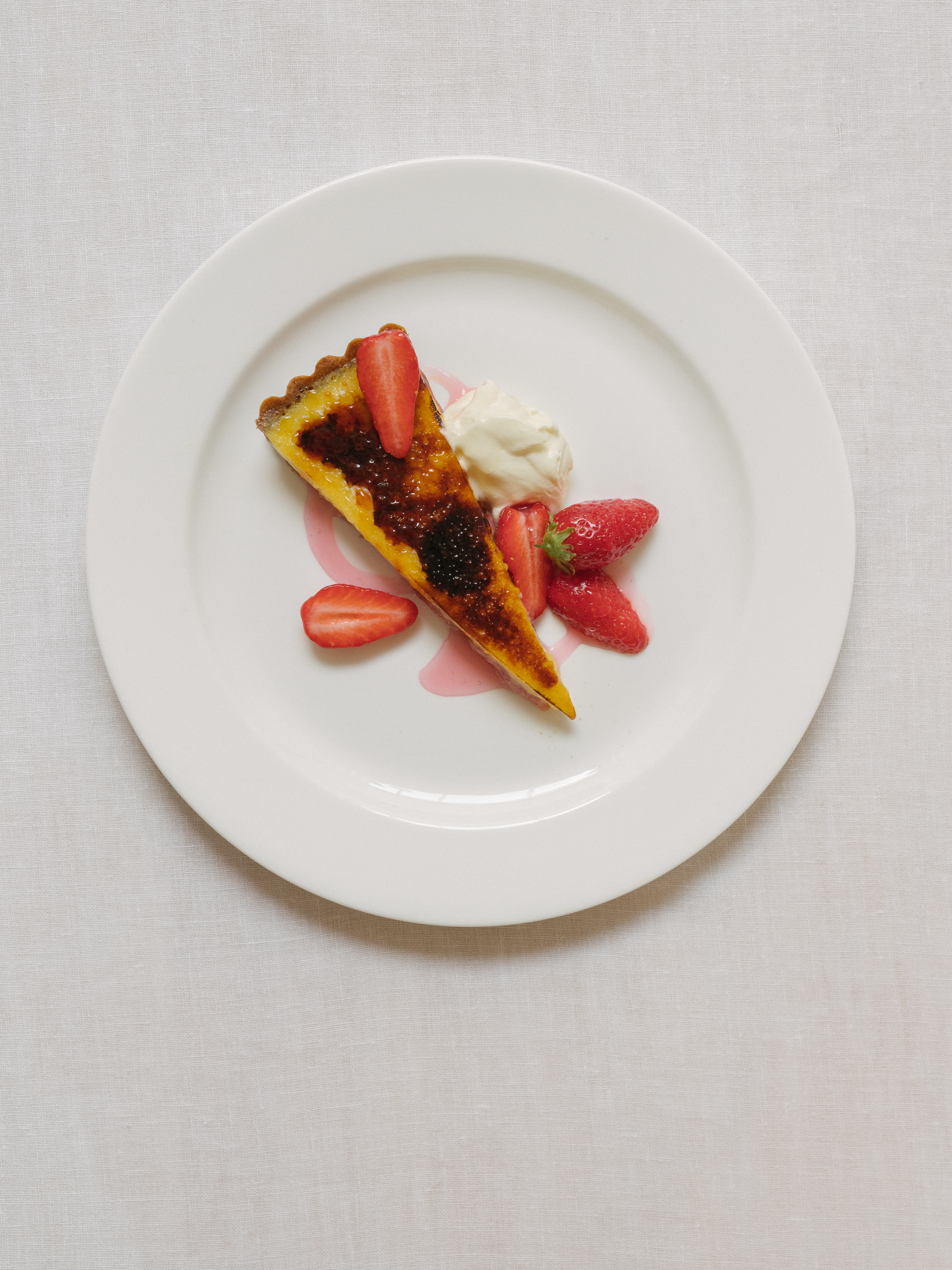 Thin wedge of cheesecake on a white plate