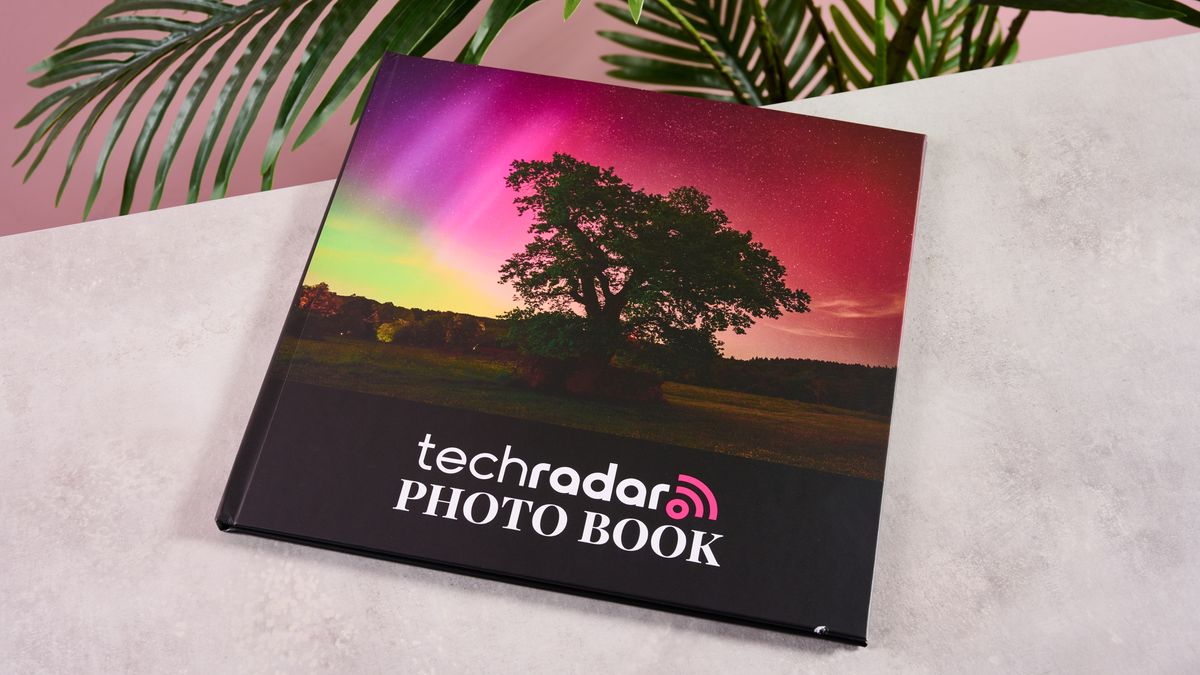 The cover of a 12 x 12 inch Blurb photo book on a marble surface in front of a plant.