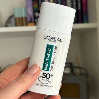 Laura holding L'Oréal Paris Bright Reveal Dark Spot UV Fluid SPF 50+ - best sun cream