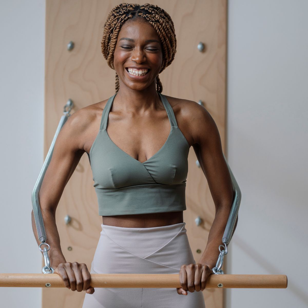 A woman working out in a studio with one of the best Pilates bars