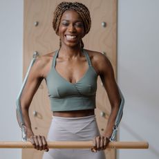 A woman working out in a studio with one of the best Pilates bars