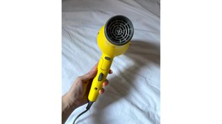 Original image showing hand-held close-up of Drybar's Baby Buttercup Travel Dryer