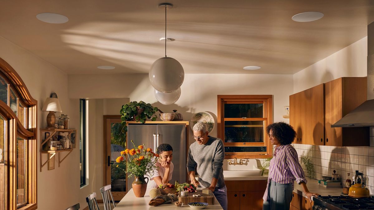 A family chatting in a kitchen with Sonos 8&quot; In-Ceiling speakers installed