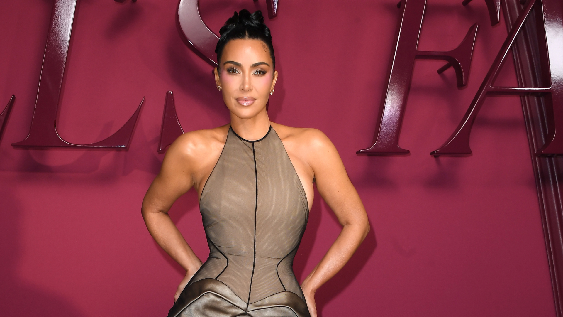 Kim Kardashian wearing an updo hairstyle and a neutral toned halter neck dress