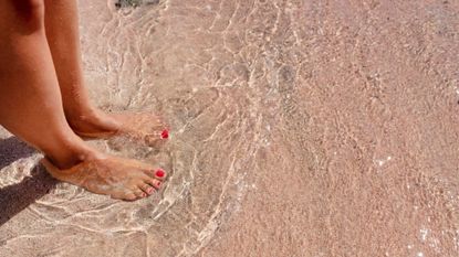 french pedicure - Woman's pedicure in the water and sand at the beach - gettyimages 1353071606