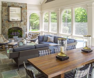 garden room with gray sofas and stone fireplace