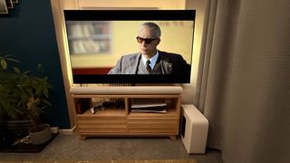 Adam Driver as Enzo Ferrari on a TV with a Sonos soundbar and subwoofer next to it