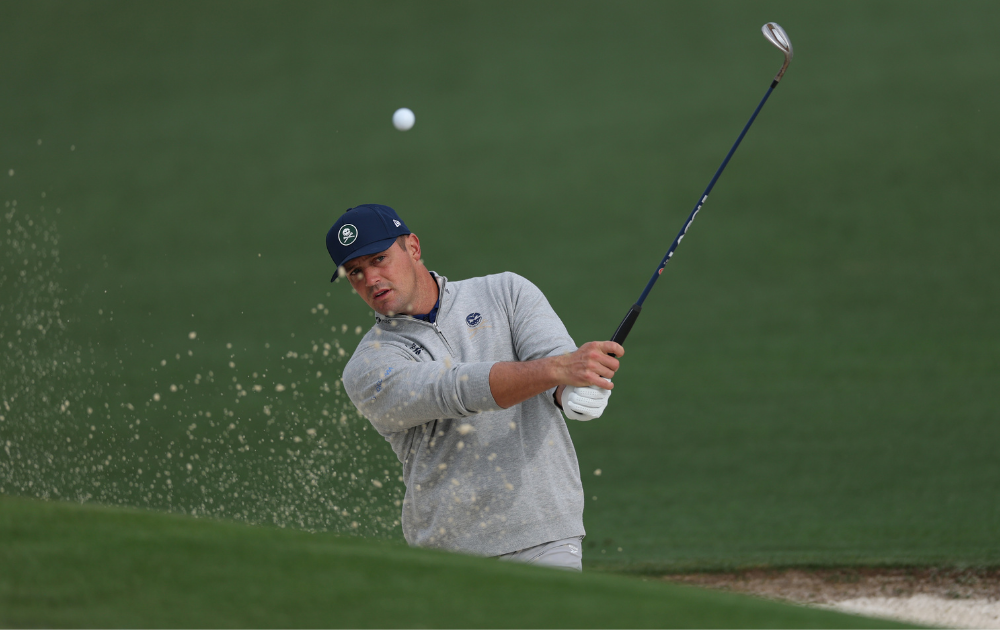 Bryson DeChambeau of the United States hits out of a greenside bunker on the second hole during a practice round prior to the 2026 Masters Tournament at Augusta National Golf Club