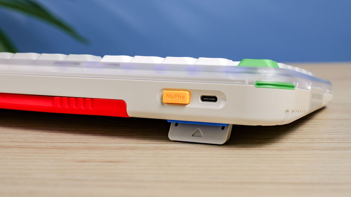The NuPhy Kick75 upper rear case with a blue wall in the background