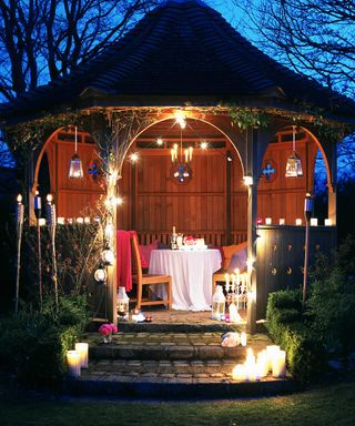 wooden gazebo with lights at night