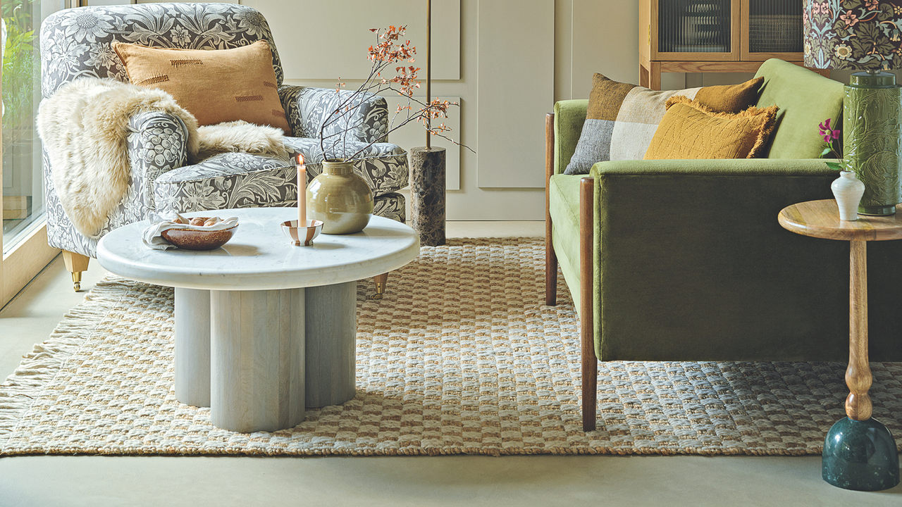 Neautral living room with stone coffee table. It has a candle, vase and bowl 