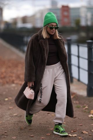 Woman wearing a fur and sweatpants.