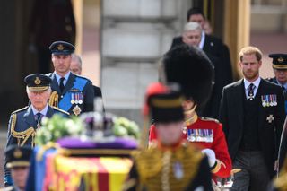 Britain's King Charles III (L), Britain's Prince William, Prince of Wales (2L) and Britain's Prince Harry, Duke of Sussex walk behind the coffin of Queen Elizabeth II