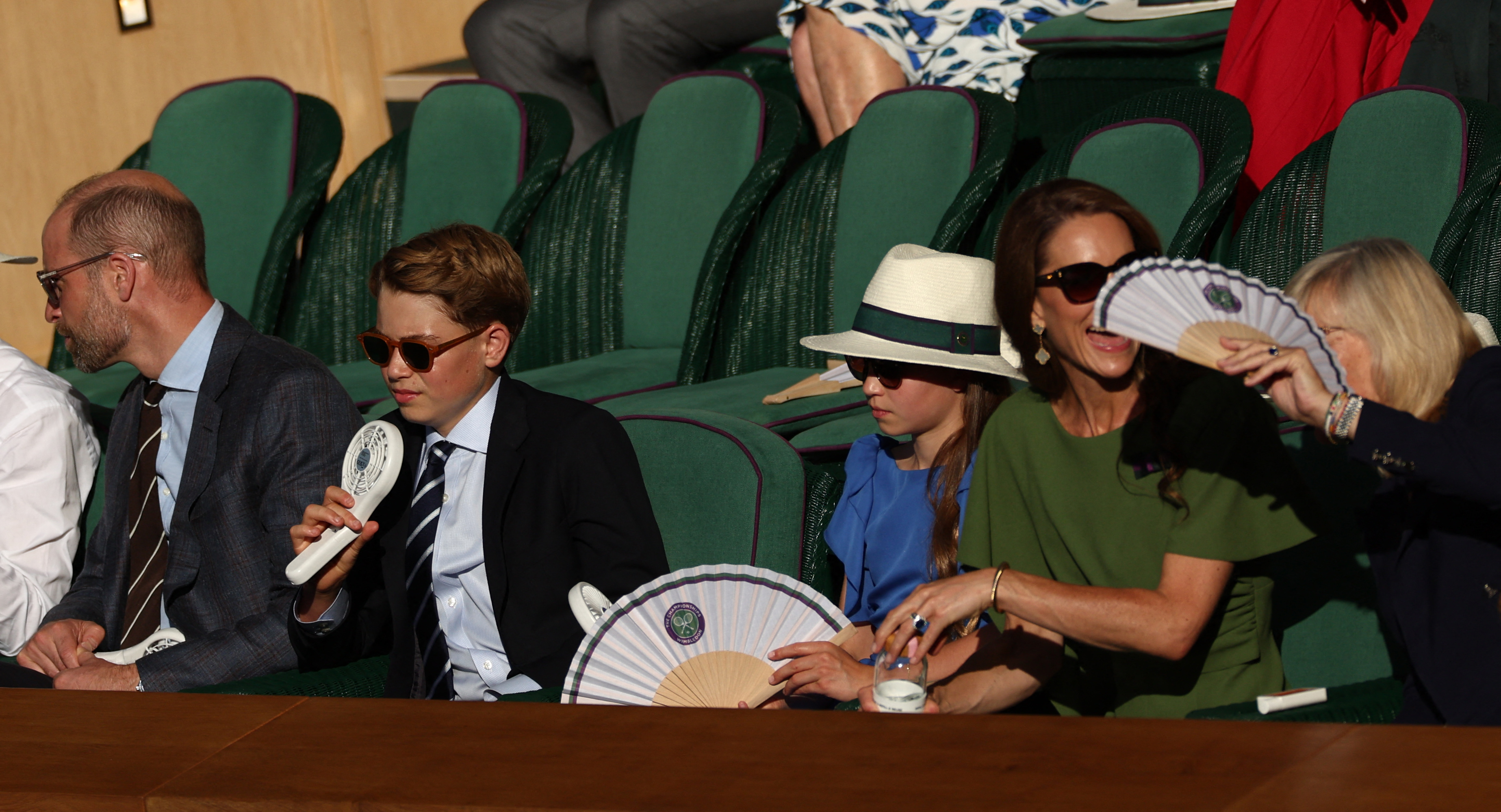 Prince George and Princess Charlotte using fans at Wimbledon