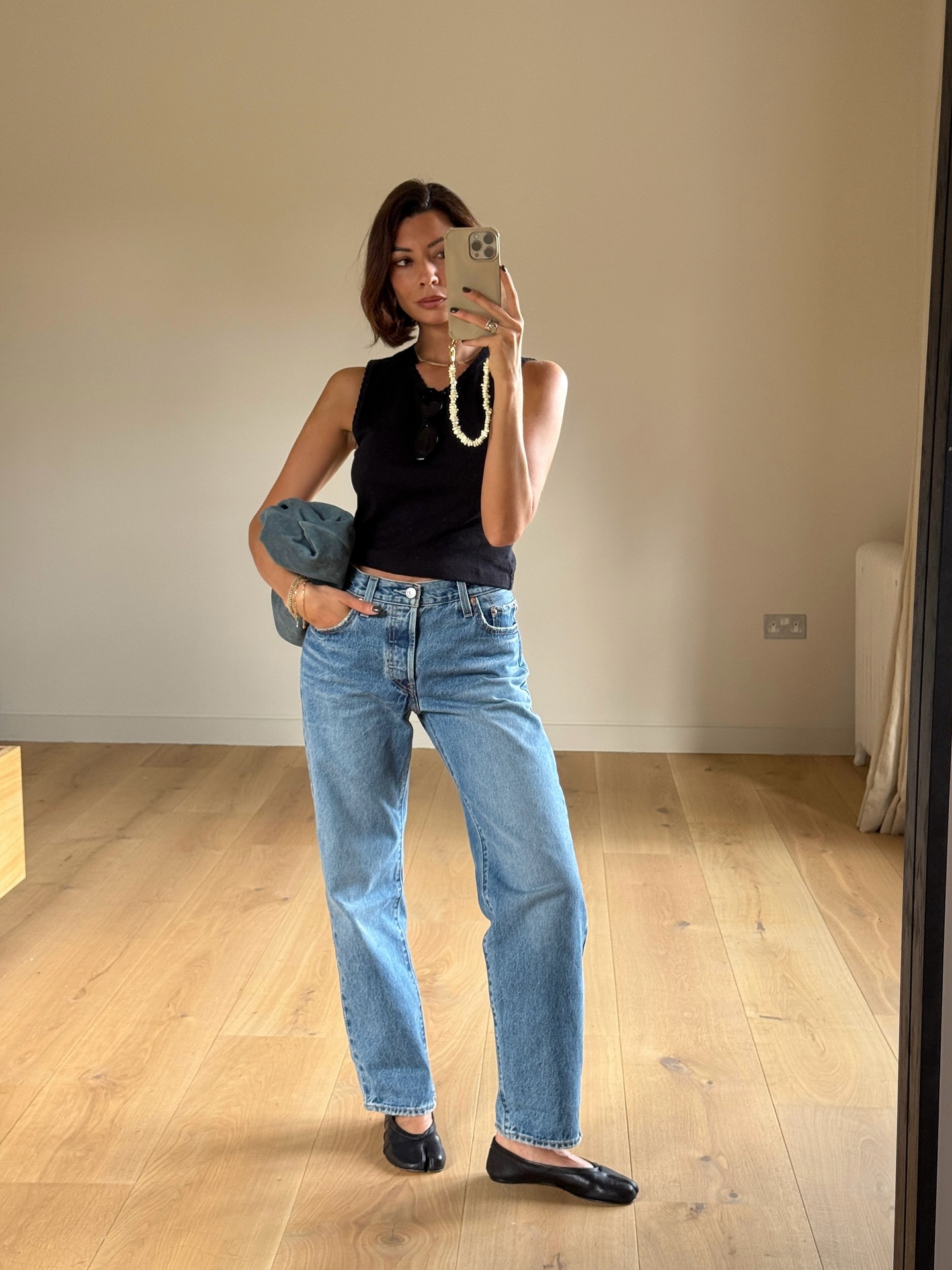 A woman taking a mirror selfie with a blunt, side-part bob hairstyle