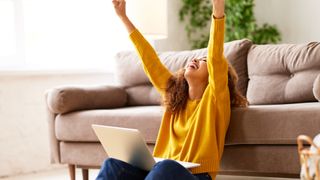 Une femme heureuse utilisant un ordinateur portable chez elle