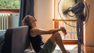 A woman sat in front of a cooling fan in a heatwave