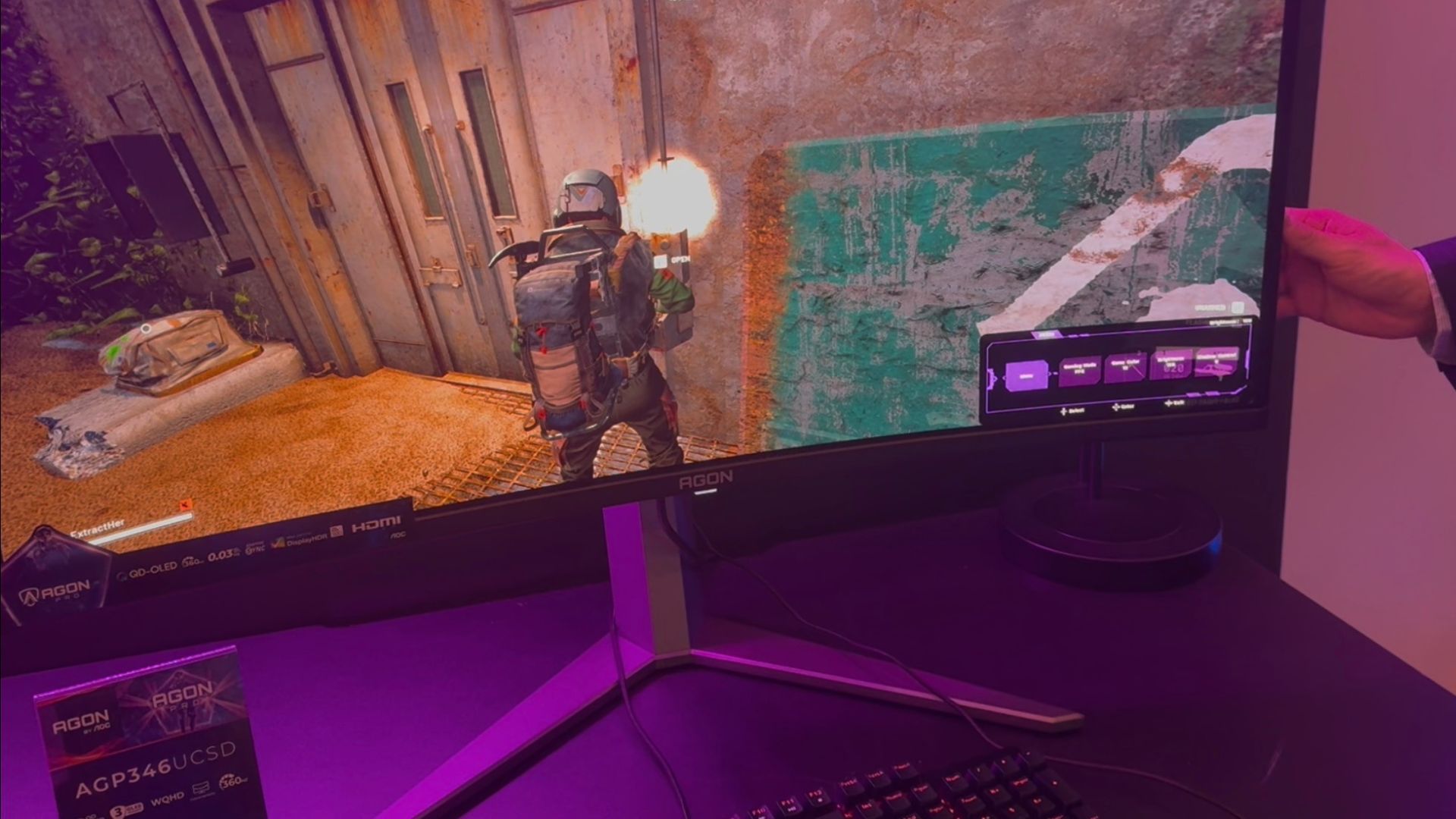 AOC OLED monitor, with a purple OSD down the bottom right, in a dimly lit room