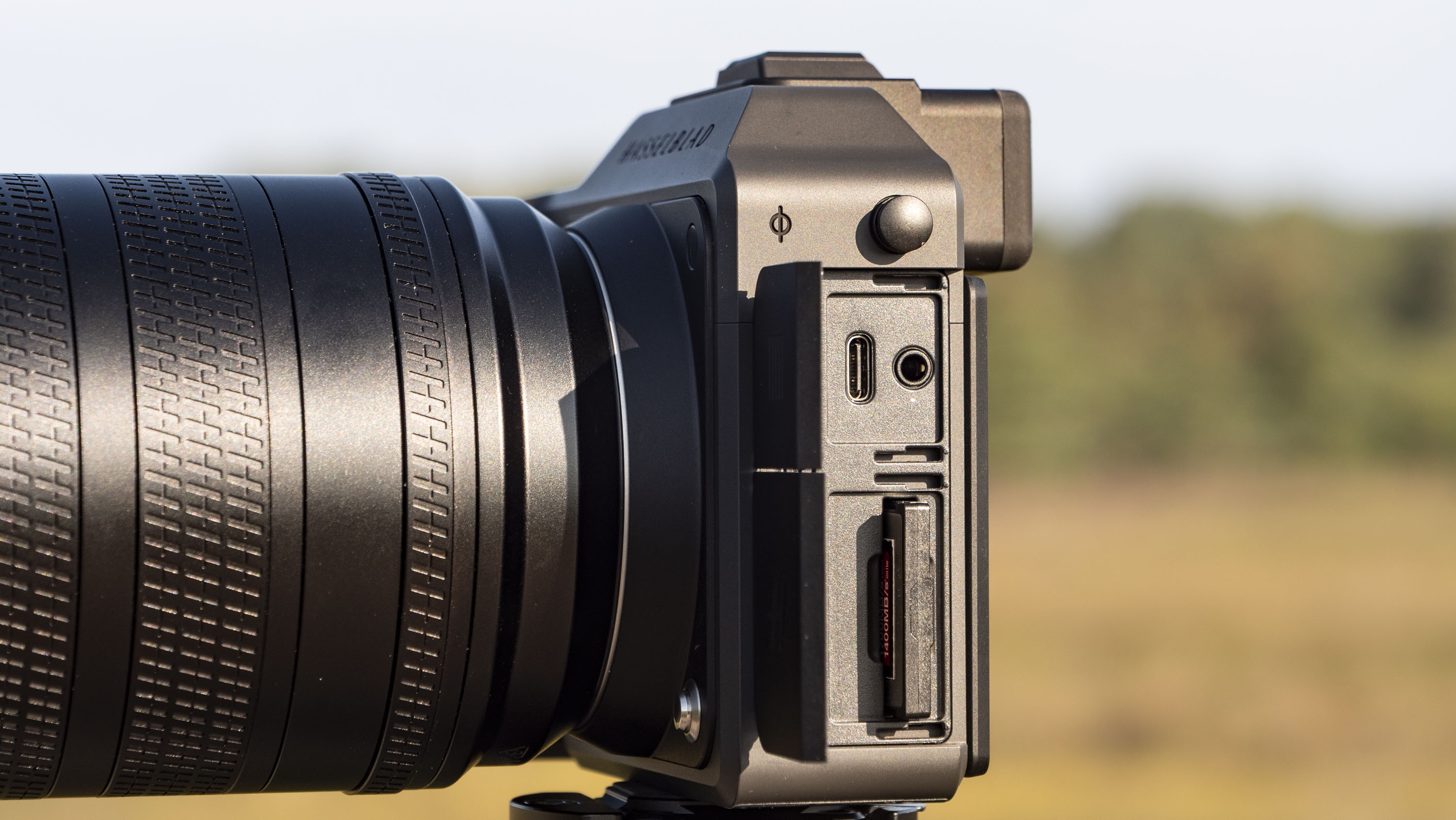Memory card and connection port doors open on the Hasselblad X2D II 100C camera outdoors at first light
