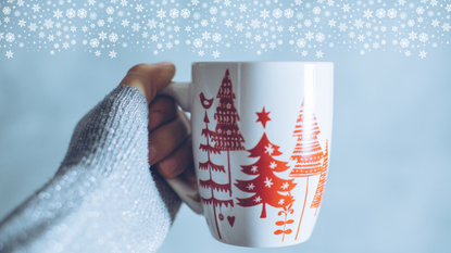 hand holding a Christmassy mug on a blud background celebrating Christmas family traditions