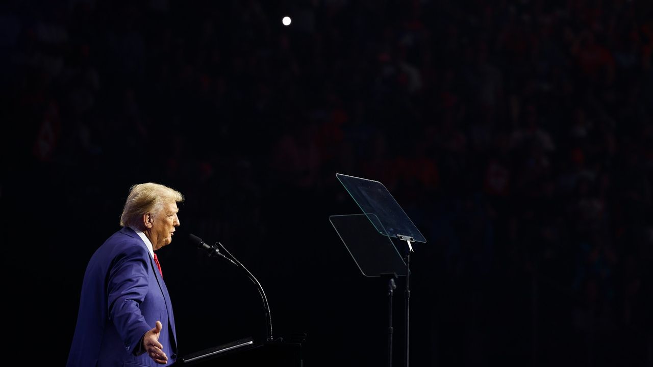 side view of trump standing at a podium, reading a teleprompter during a speech