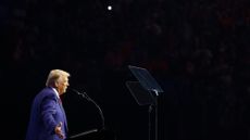 side view of trump standing at a podium, reading a teleprompter during a speech