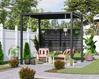 Patio with black slatted wooden pergola, red cushioned mid-century outdoor chairs and landscaped gray patio with trimmed shrubs and lawn and hanging baskets