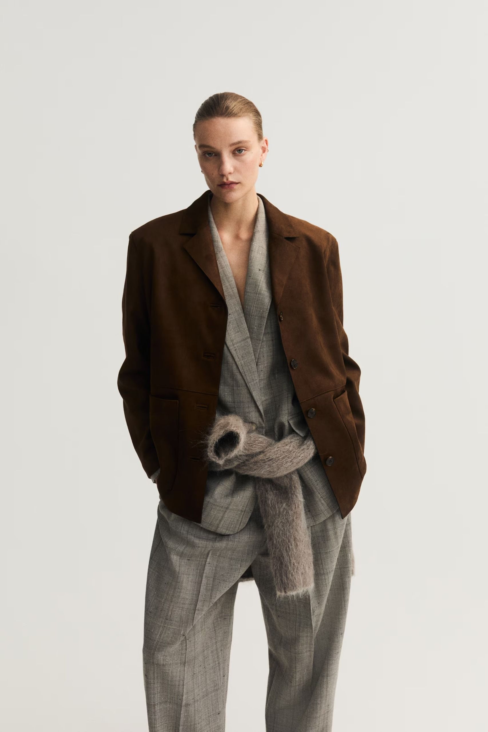 An H&M model wearing a suit with a suede blazer layered over the top
