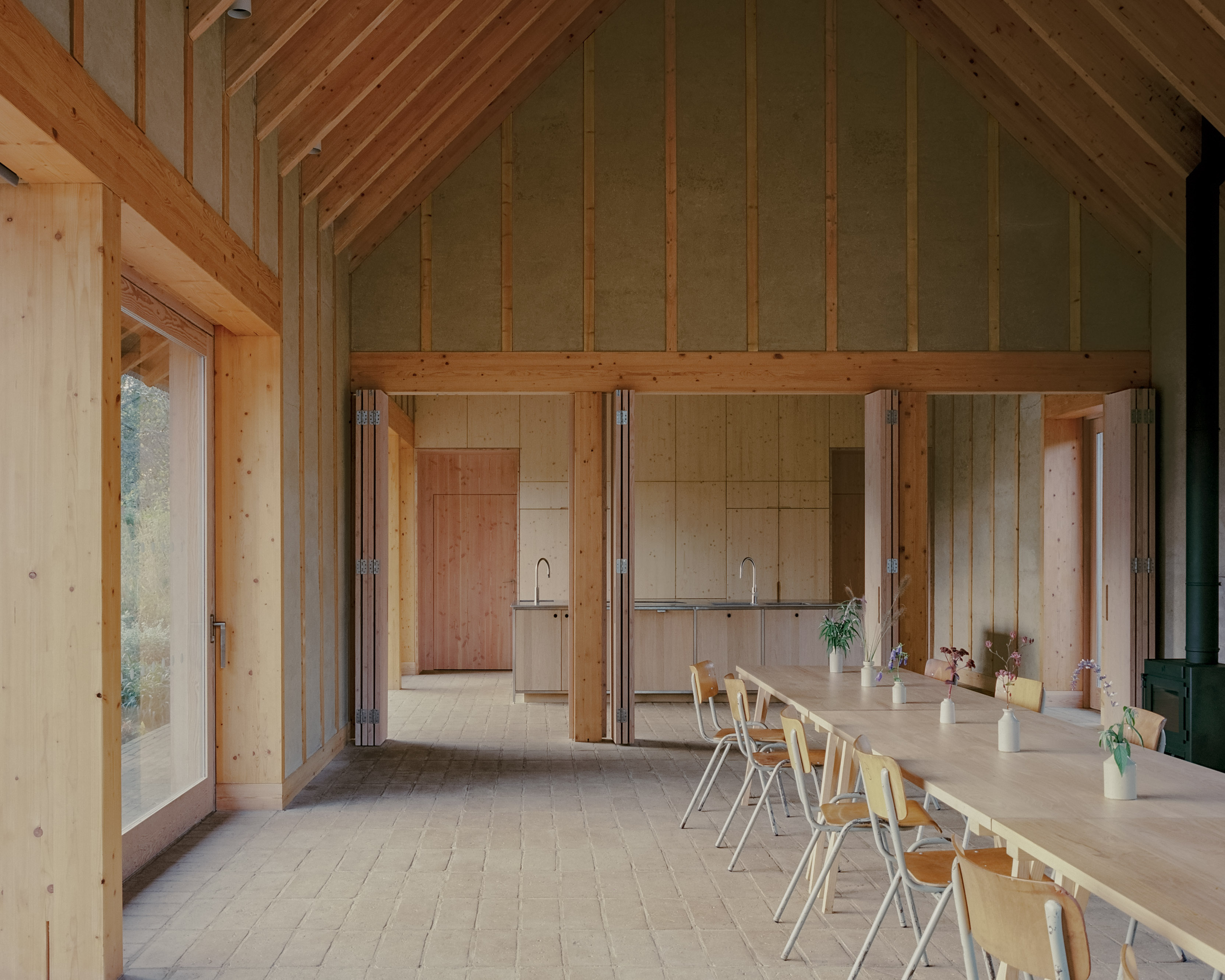 The Apple House, timber building with shingles and pitched roof set among wildflower fields