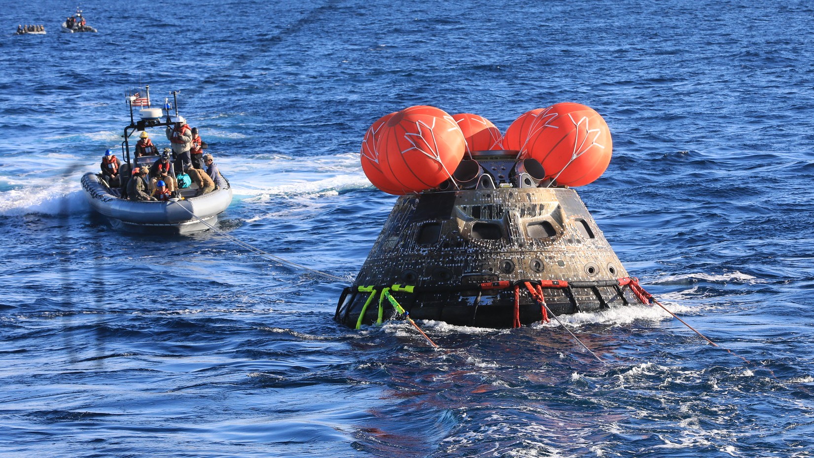 A photo of the Artemis I Orion capsule in the ocean after splashdown. 