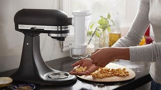 Woman making pasta with a KitchenAid pasta machine