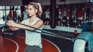 Woman working out with resistance band in the gym