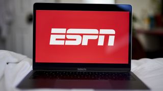 the ESPN logo is on a laptop open on a bed