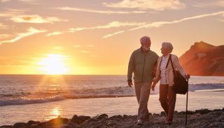 AI image of an elderly couple on the beach at sunset