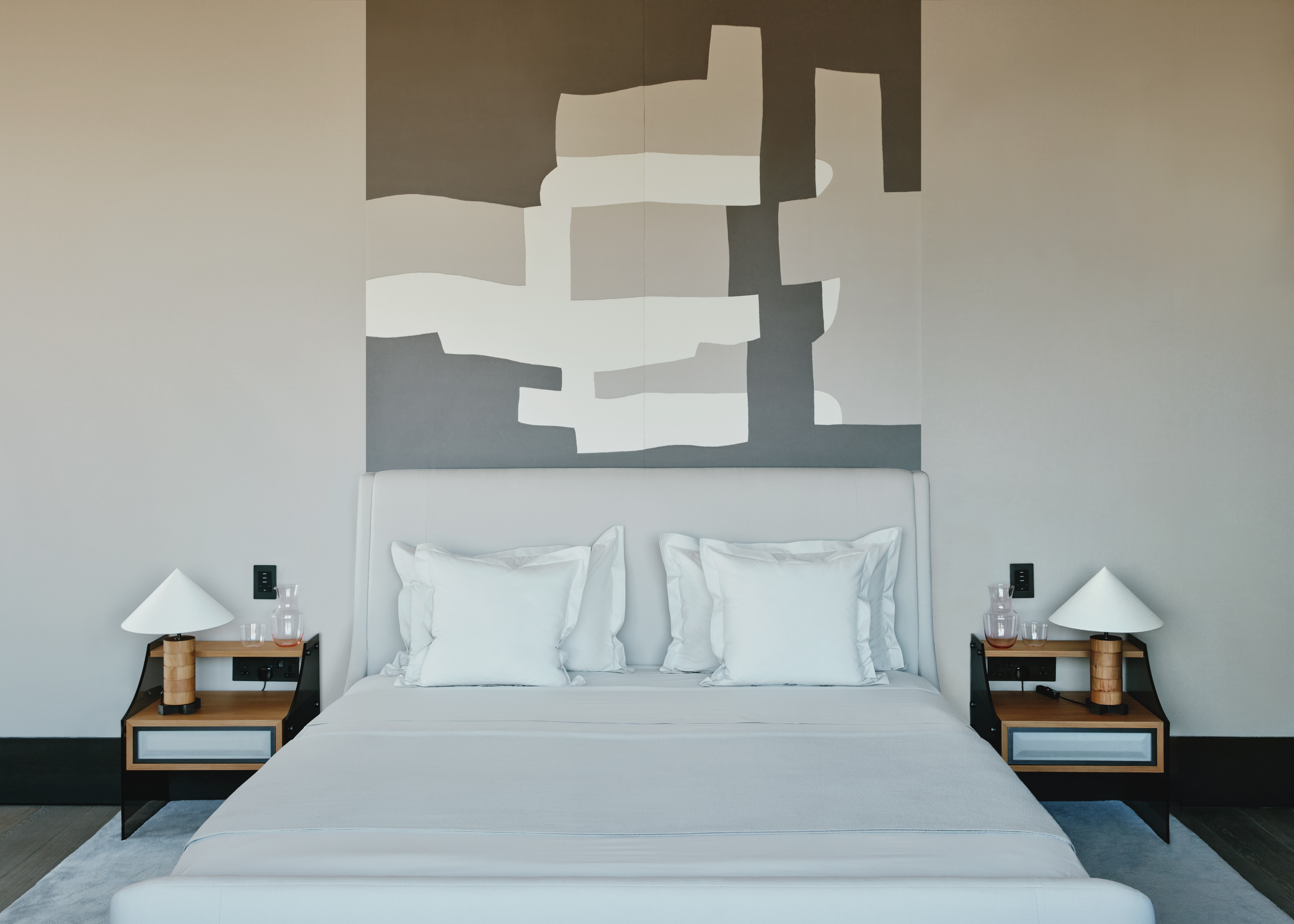 A contemporary bedroom with upholstered cream cashmere walls