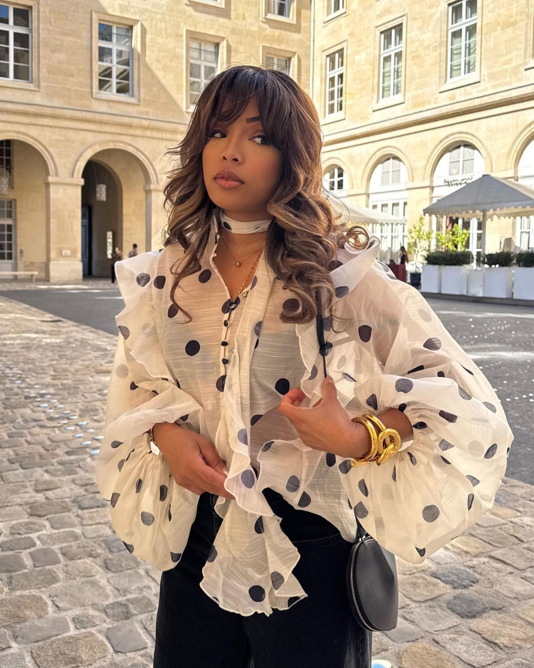 Influencer wears a polkadot blouse.