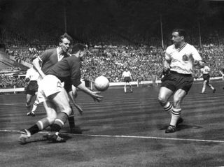Manchester United goalkeeper Harry Gregg saves from Bolton's centre-forward Nat Lofthouse in the 1958 FA Cup final.