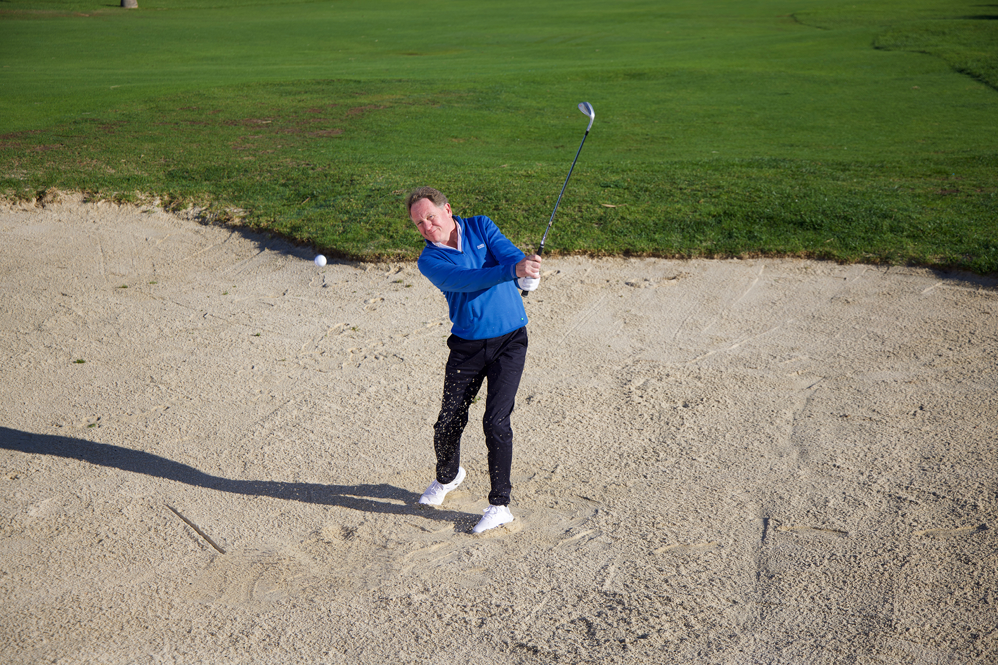 Keith Wood hitting a bunker shot with plenty of spin, in a half finish position