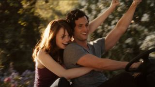Emma Stone and Penn Badgley riding a lawn mower while throwing their fist up in Easy A.