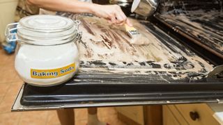 Oven being cleaned with baking soda for quick affordable kitchen cleaning hack
