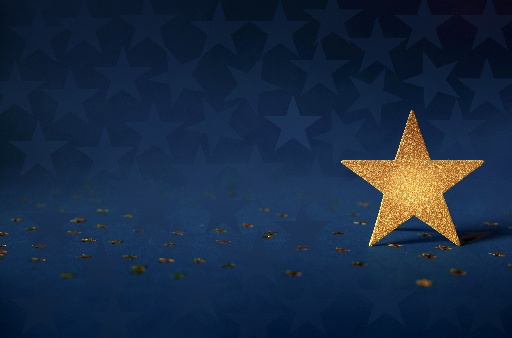 large gold star with blue background and small gold stars scattered around it