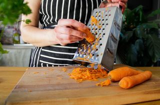 person grating carrots