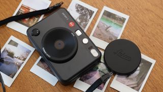 Leica Sofort 2 camera surrounded by Instax Mini prints