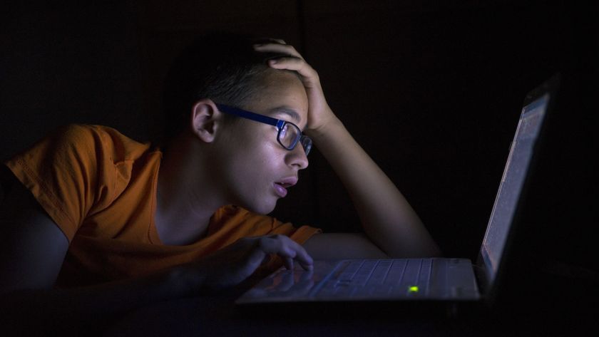 Young Teen in front of a laptop computer and on a bed, night time student