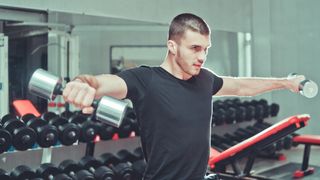 Man performing lateral raise with dumbbells